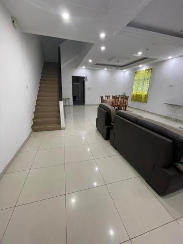 a living room with two couches and a staircase at 7 Rooms Budget 3 Tingkat USM Gelugor Georgetown in Gelugor