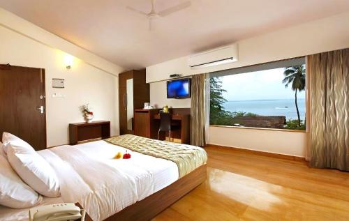 a bedroom with a large bed and a large window at The Hawaii Comforts Panjim in Panaji