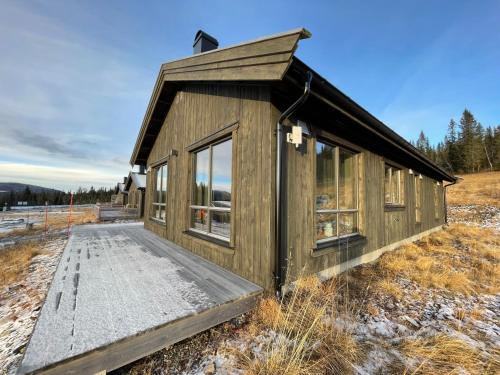 a small wooden building in a field at Hjertebo by Norgesbooking - cabin at Spåtind in Nord Torpa