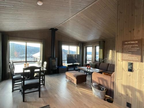 a living room with a table and a couch at Hjertebo by Norgesbooking - cabin at Spåtind in Nord Torpa