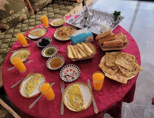 una mesa cubierta con platos de comida y tazas de naranja en Safi vacances, en Zri Ouled