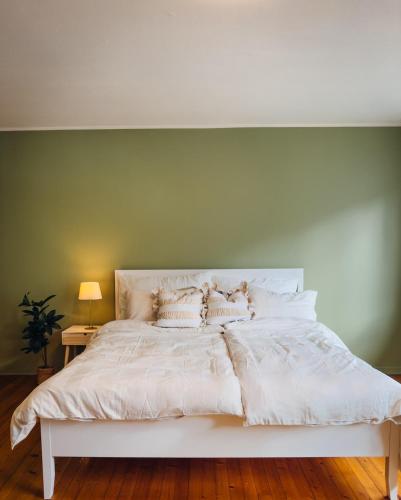 a white bed with pillows on it in a bedroom at Stor innbydende leilighet med 4 soverom og sentral beliggenhet in Notodden