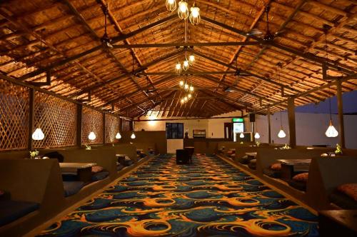 a dining room with tables and a large carpet at The Hampi Cafe in Hampi