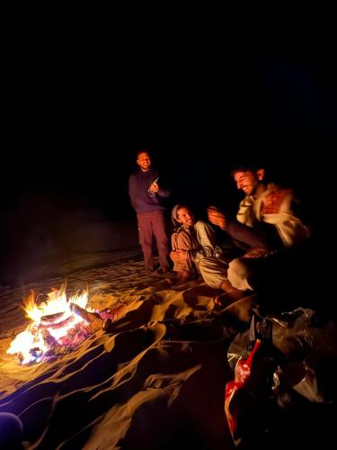 a group of people sitting around a fire at Hostel Peace & Love Home Stay in Jaisalmer
