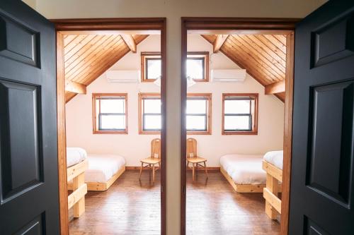 a room with two beds and a table at Mominoki Lodgeモミの木ロッジ in Minakami