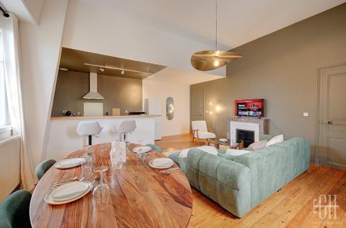 un salon avec une table et un canapé dans l'établissement Appartement avec chambre, parking, bureau, wifi, à Tours