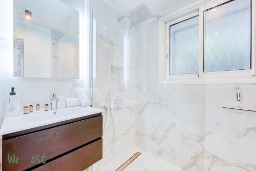une salle de bain blanche avec un lavabo et une douche dans l'établissement Beautiful apartment close to beaches and palaces, à Cannes