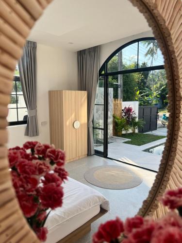 een spiegelreflectie van een slaapkamer met een bed met rode bloemen bij The Brova villa- Beautiful Private 3 bedroom villa in Nathon Bay