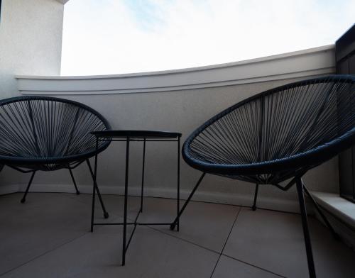 two chairs and a table in a room at Novos Luxury Suites in Bucharest