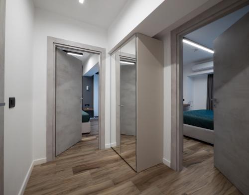 a hallway with mirrored doors and a bedroom at Novos Luxury Suites in Bucharest