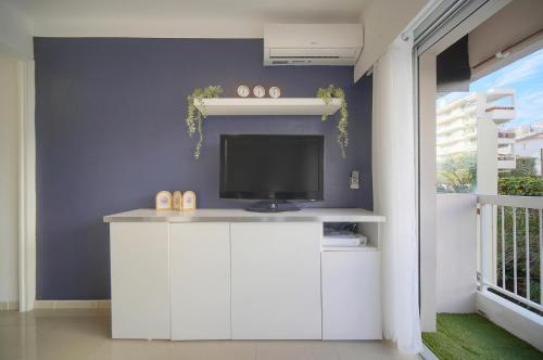 - un salon avec une télévision sur un meuble blanc dans l'établissement Le Fili - 5min Mer- Wifi-Clim - VCA, à Cannes