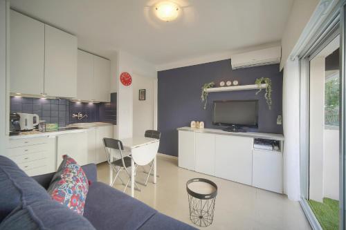 un salon avec un canapé et une cuisine dans l'établissement Le Fili - 5min Mer- Wifi-Clim - VCA, à Cannes