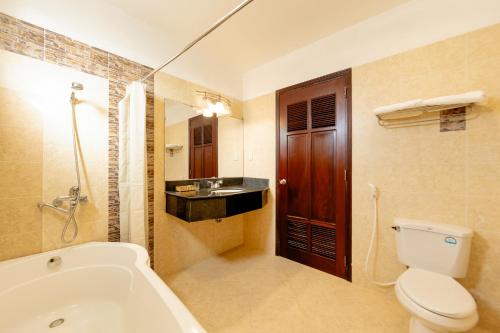 a bathroom with a tub and a toilet and a sink at Hùng Phong Hotel - Near Dalat Market in Da Lat