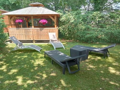 a gazebo with a table and two chairs and a picnic table at La Roulotte du Parc in Saint-Priest-des-Champs