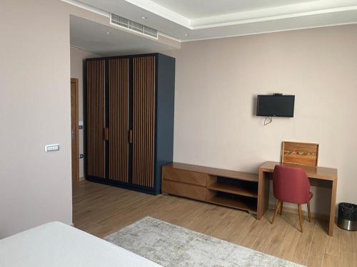 a room with a desk and a television on a wall at Hotel Vila Aleksander 1 in Shijak