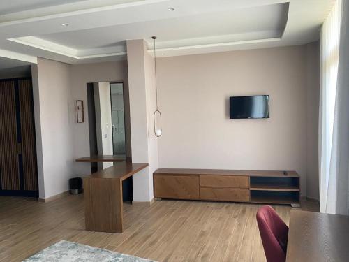 a living room with a tv on a wall at Hotel Vila Aleksander 1 in Shijak