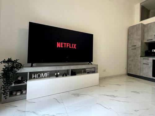 a flat screen tv sitting on a tv stand in a living room at Elegant & Luxe a 200m da Stazione e Aereoporto di Ciampino in Ciampino