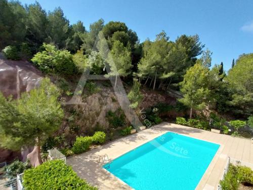 une vue aérienne d'une piscine dans un jardin dans l'établissement T3 capacite 6 personnes dans residence avec piscine et garage, à Sète