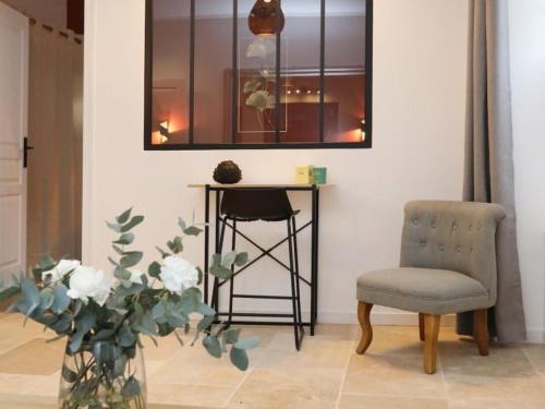 une table, une chaise et un vase avec des fleurs dans l'établissement Notre Dame de Senlis by La boite en Plus, à Senlis