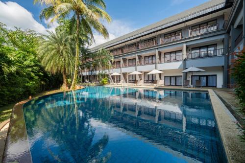 a swimming pool in front of a building at Kokotel Khao Lak Montana in Khao Lak
