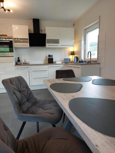 a kitchen with a large wooden table and chairs at FeWo's Weinbergblick Wintrich by Brauneberger Hof in Wintrich