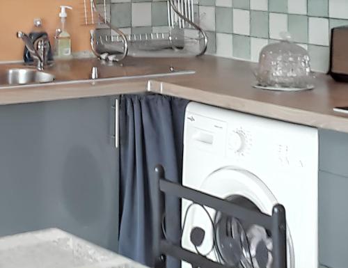 une cuisine avec une machine à laver sous un comptoir dans l'établissement Maison charmante à L'Isle-sur-la-Sorgue avec jardin clôturé, à LʼIsle-sur-la-Sorgue
