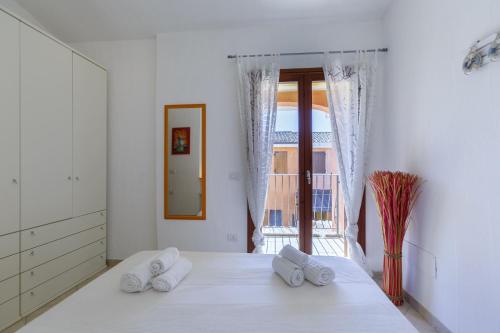 een slaapkamer met een bed met twee handdoeken erop bij Villa Mama con piscina condominiale, giardino e barbecue in SantʼAnna Arresi