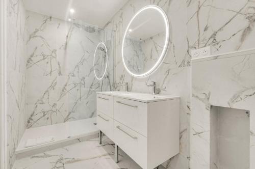 une salle de bain blanche avec un lavabo et un miroir dans l'établissement Comptoir des Étoffes - Proche Place du Capitole, à Toulouse