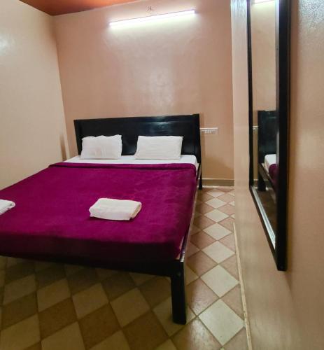 a bedroom with a large bed with purple sheets at Hotel Hill Town Coorg in Madikeri