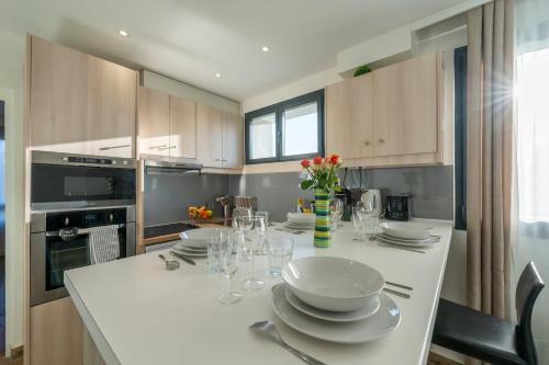 une cuisine avec une table avec des assiettes et des verres à vin dans l'établissement Les Coteaux 4 - Avec jardin à Argenteuil, à Argenteuil