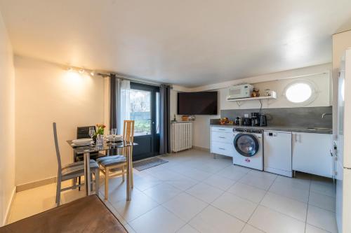 un salon avec une table et une cuisine dans l'établissement Les Coteaux 5 - Appt avec jardin à Argenteuil, à Argenteuil