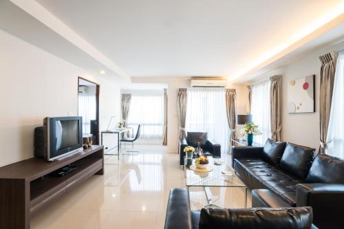 a living room with a couch and a tv at Beyond Suite in Bangkok
