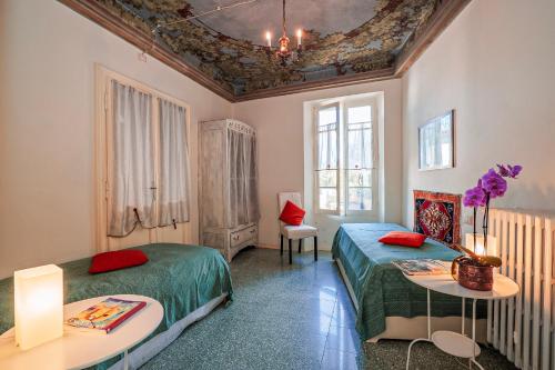 a bedroom with two beds and two tables and a ceiling at Casa Terra a Cielo in Castelveccana