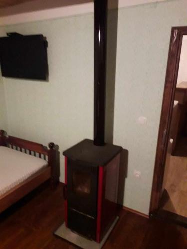 a room with a stove in a room with a bed at Stara hiža in Radakovo
