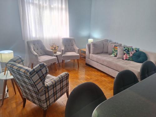a living room with a couch and two chairs at Apartamento no Centro in Poços de Caldas