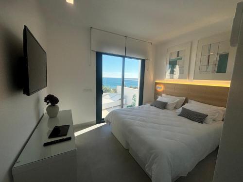 San RoqueにあるBEST Sea view Sotogrande Torreguadiaroのベッドルーム(ベッド1台、テレビ、窓付)