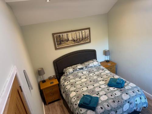 a bedroom with a bed and a picture on the wall at Millstone Stables Cottage in Chinley