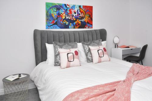 a bedroom with a large bed with pink pillows at Townhouse @ Aboyne Close Birmingham in Birmingham