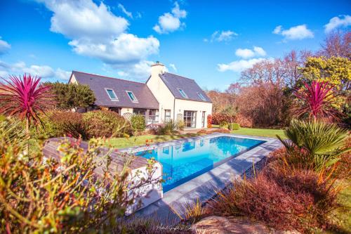 une maison avec une piscine dans la cour dans l'établissement Maison pour 10, avec un grand jardin et une piscine, à Penvénan