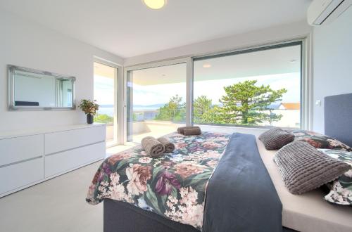 een slaapkamer met een bed en een groot raam bij Villa I Residence in Punat