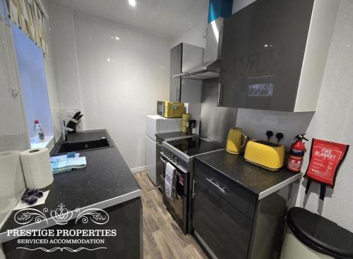 a kitchen with a black counter top and a stove at 52 Wordsworth Street by Prestige Properties SA in Barrow in Furness