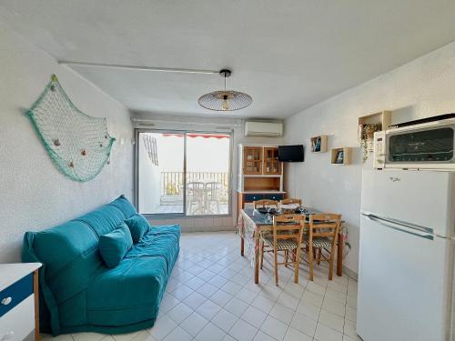 un salon avec un canapé bleu et une table dans l'établissement Sol-y-Days Hermes, Charmant studio cabine au calme, à La Grande Motte