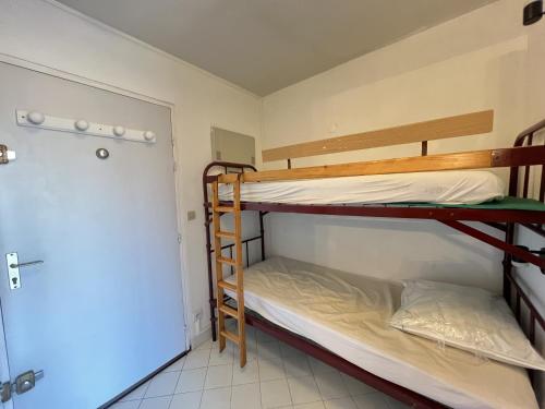 - 2 lits superposés dans une petite chambre avec une porte dans l'établissement Sol-y-Days Hermes, Charmant studio cabine au calme, à La Grande Motte
