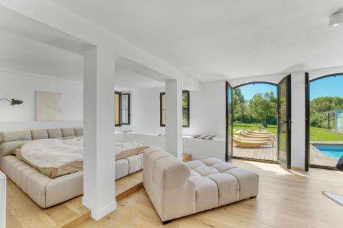 Un dormitorio blanco con una cama y un sofá. en Villa Valbonne, en Valbonne