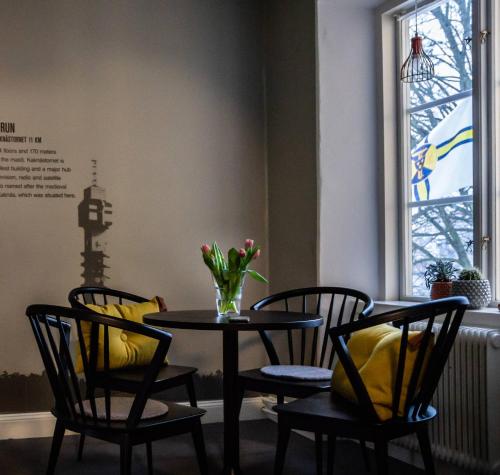a table and chairs with a vase of flowers on it at STF Stockholm Skeppsholmen Vandrarhem in Stockholm