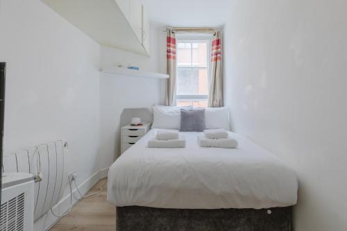 a white bedroom with a bed with two pillows at Central 1BD Flat 6 minutes to Old Street station in London
