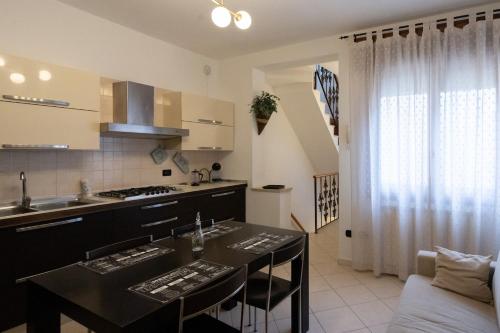 Una cocina con una mesa con sillas y una encimera. en Casa Lulù, en Chioggia