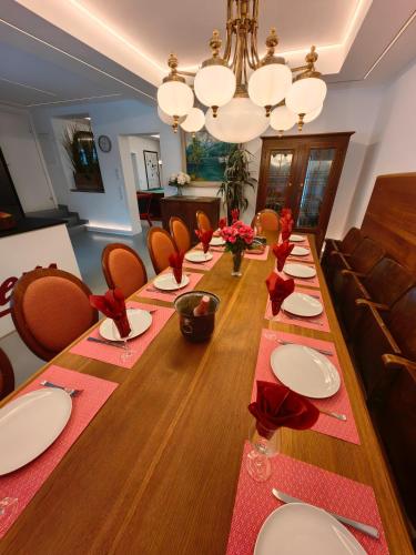 a long dining room table with red napkins and chairs at Thurners Dependance in Bruck an der Großglocknerstraße