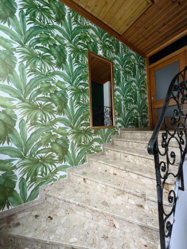 a stairway with a wall with a mural of leaves at Thurners Dependance in Bruck an der Großglocknerstraße