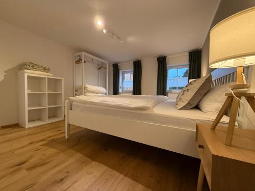 a large white bed in a room with windows at Ferienwohnung "Beim Xander" in Altenstadt